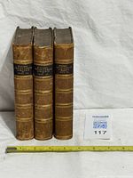 Spine view of all three volumes with measuring tape