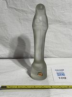 Full view of frosted glass sculpture with measuring tape indicating height