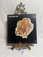 Front jacket on stand showing cover art and label logo