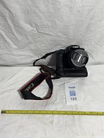 Camera with battery grip and strap, lens cap attached