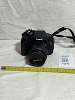 Front view of Canon EOS Rebel T3i with 18-55 mm lens and strap