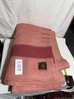 Folded pink wool blanket showing darker stripe and edges