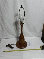 Full view of wood table lamp with tape measure for scale