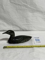 Profile of soapstone goose with measuring tape showing length