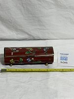 Closed box front with floral cloisonné, tape measure for length