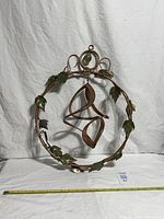 Full view of circular copper wind spinner with tape for scale