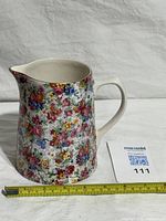 Front view of ceramic pitcher with measuring tape for scale
