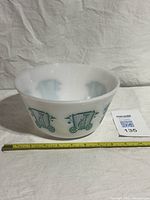 side view of milk glass bowl with circus wagon tiger graphic and tape measure showing diameter