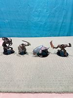 Four sample D&D miniatures standing on fabric surface