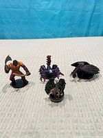 Group shot of four D&D miniatures: Sand Giant, purple multi-headed creature, black dragon, small brown creature