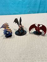 Front view of three dragon miniatures