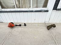 Full view of Echo SRM-225 trimmer laying on pavement