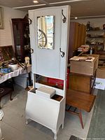 Full view of hall tree showing mirror, hooks, storage bin, overall white finish