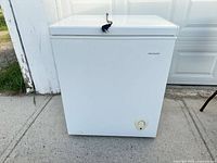 Front view of white Frigidaire chest freezer showing lid and front control dial