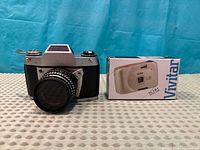 Exakta 500 camera with attached lens beside boxed Vivitar IC101