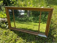 Front view of three-pane mirror leaning on grass