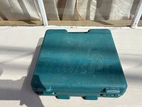 Closed teal Makita carrying case on surface