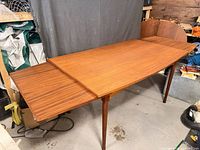 Full view of teak dining table with leaf extended