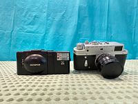 Olympus XA2 with A11 flash next to Zorki-4 with Jupiter-8 lens front view