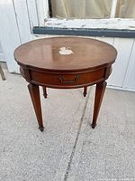 Full view of table showing round top, legs, overall condition