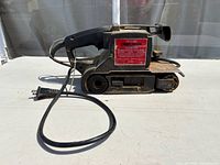 Left side view of Craftsman belt sander showing body, cord and plug