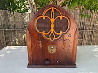 Front view of arched wooden Magnavox radio showing grille, controls and overall condition