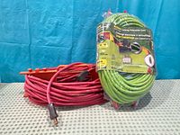 Green packaged RiteCord cord upright beside coiled red cord on orange winder