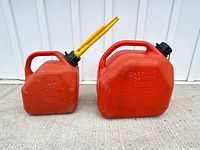 Front view of both red gasoline cans, showing sizes and overall wear