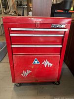 Front view of red Waterloo Shop Series rolling toolbox showing drawers, cabinet and stickers