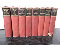 Eight red cloth hardcover books standing upright