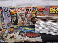 Multiple stacks of assorted hot rod magazines including Hot Rod, Rod & Custom, Car Craft, Rod Action