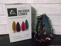 Front view of boxed incense cones beside ceramic burner