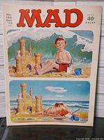 Front cover showing Alfred E. Neuman seated by sandcastle, wave background