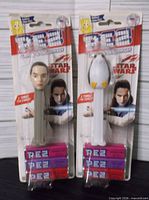 Front view of both sealed PEZ packs showing Rey and Porg dispensers with candy rolls