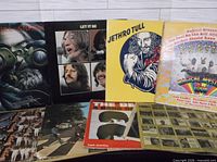 Assortment of Beatles and Jethro Tull album covers displayed