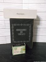 Black retail box labeled Monogrammer and Templates, white Kenmore case, green Ruffler Pleater box