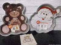Both Wilton pans, bear and Santa, with inserts visible