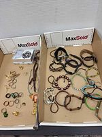 Overview of two trays with bracelets, rings, cufflinks, tie clips, brooch box