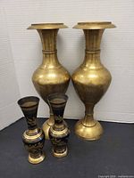 Four vases, two large etched brass and two small black enamel brass floral