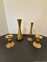 Group view of two brass vases and two brass candlesticks