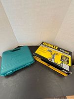 DeWalt drill kit box beside teal ROK case