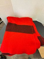 Folded red blanket showing brown stripe