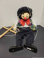 Full view of clown marionette with strings and control bar