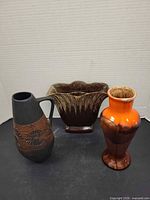 Three mid-century pottery vases displayed together