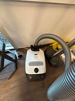 Miele S2 Continuum canister vacuum with hose and floorhead visible