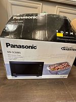 Sealed retail box front showing Panasonic NN-SC688S model and product image