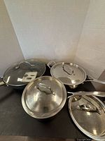 Group shot of three cookware pieces with four lids