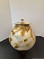 Front view of rounded stoneware jar with lid