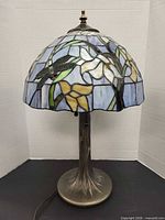 Full view of lamp showing stained glass shade and metal base