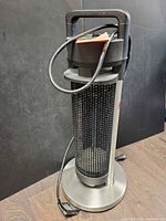 Full view of tower heater showing front grill, base and power cord